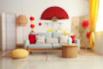 Blurred view of living room with grey sofa and decorations for Chinese New Year celebration