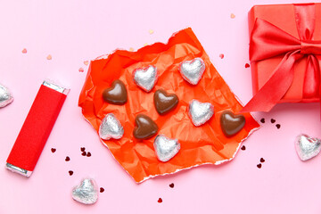 Fototapeta premium Chocolate bar and candies with gift box on pink background. Valentine's Day celebration