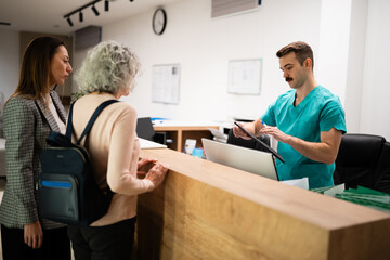 Patients checking in at clinic reception desk