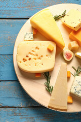 Board with tasty cheese on blue wooden background