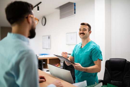 Medical professional helping patient at hospital reception desk