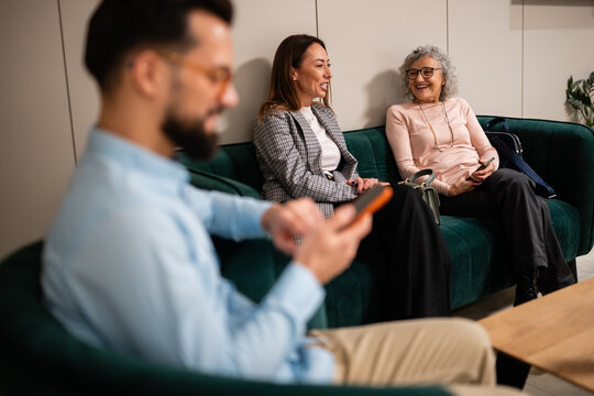 People relaxing in modern lounge with smartphones - Powered by Adobe