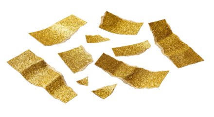 Scattered torn golden glitter paper pieces with rough edges on a clean white background, creating an abstract and festive texture composition.