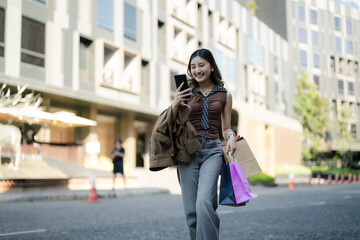 Obraz premium Young asian woman shopping using phone in city