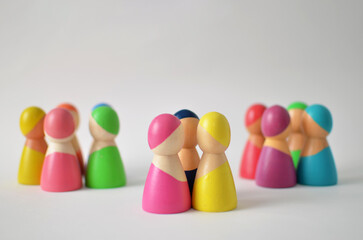 Colorful wooden figures forming diverse social groups representing community