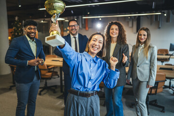 Diverse business team celebrating achievement receiving golden trophy award