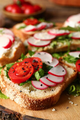 Board with delicious radish bruschettas, closeup