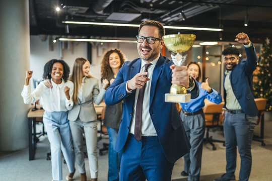 Fototapeta Business team celebrating achievement with a winning trophy