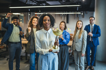 Business team celebrating achievement with a winning trophy