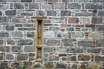 Hand cut stone natural stone block wall with rocks mortared together, as a rustic patterned background
