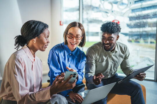 Diverse business colleagues collaborating with technology in modern office