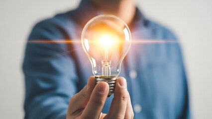 Businessman holding a glowing lightbulb representing a new idea and innovation.