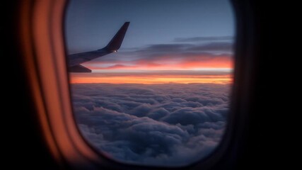 Aerial view through airplane window of sunset sky over clouds - Powered by Adobe