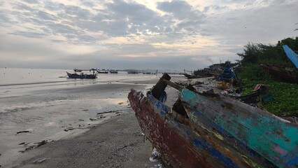 sunset atmosphere on a beach full of fishing boats