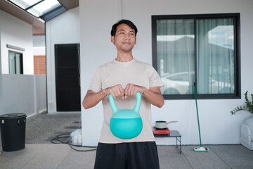 A man is holding a kettlebell in his hands