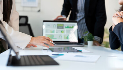 Professional team members are engaged in a strategic business meeting, analyzing financial and marketing