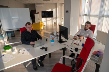 Two Caucasian men working in an office. 