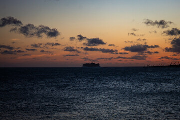 Portrait of the silhouette of a ship at sea at sunset.