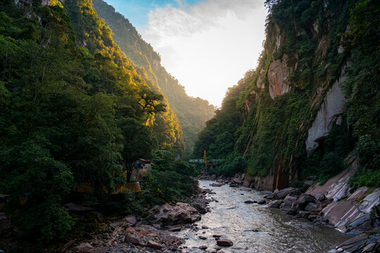 Scenic river flowing through a deep canyon with lush Amazon rainforest cliffs at sunset in Tingo María, Peru. - Powered by Adobe