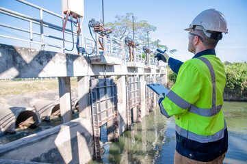 A specialist engineer is testing the water gate opening and closing system of a dam. © akarapon