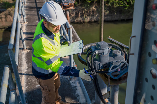 A specialist engineer is testing the water gate opening and closing system of a dam.