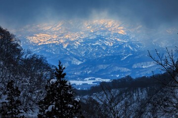 Golden Peaks: Sunlit Snow-Capped Mountains Breaking Through Winter Storm Clouds, Nagano, Japan