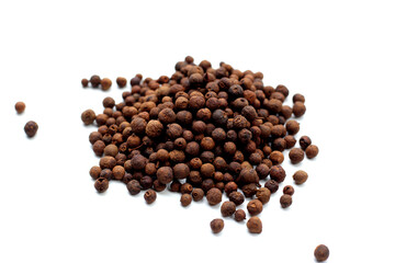 A heap of dark-brown, aromatic allspice berries on a white background.