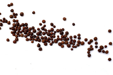 A heap of dark-brown, aromatic allspice berries on a white background.