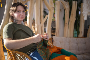 Hipster feminine male crochet handmade knitting hobby with colored yarn and hook at wooden interior