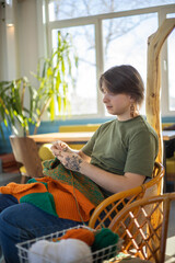 Hipster feminine male crochet handmade knitting hobby with colored yarn and hook at wooden interior