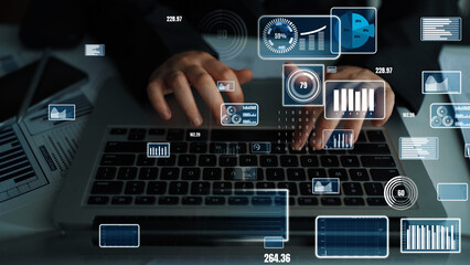 Close-up view of hands typing on a laptop, showcasing interactive data visualizations, charts, and graphs on a modern digital interface, emphasizing business productivity. Xenic