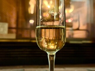 Close-up of champagne glass with fireplace behind