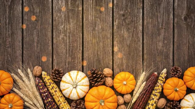 Autumn harvest border with pumpkins, Indian corn, pinecones, and wheat on a rustic wooden background, perfect for Thanksgiving celebrations.