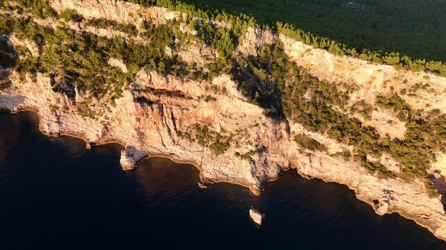 Drone flight along Telascica cliffs on Dugi Otok, golden light above the dark Adriatic sea, revealing Croatia&rsquo;s dramatic national park coastline.