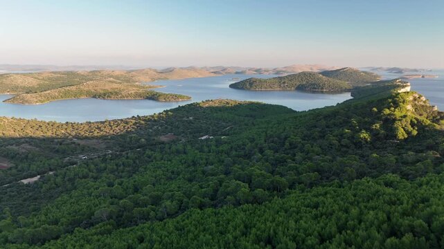 Drone glides over Telascica&rsquo;s forest and bays, flying towards Kornati islands in golden sunset light.