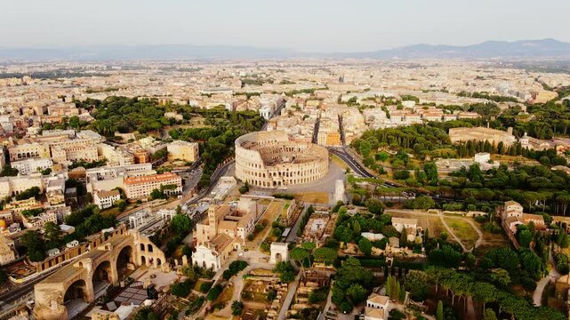 Warm cinematic aerial of Rome&rsquo;s Colosseum with golden light and distant hills