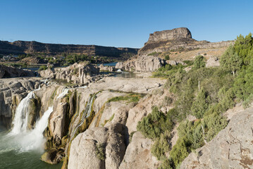 Aerial View of Gigantic Shoshone Waterfall and hydroelectric power plant, with the massive water cascading down into a serene pool in the Snake River. 