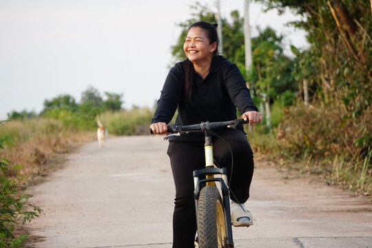 active lifestyle, bicycle, biking, black long sleeve, break, communication, conversation prep, cycling break, friendship, green background, greeting, hand gesture, hello, leisure time, outdoor exercis - Powered by Adobe