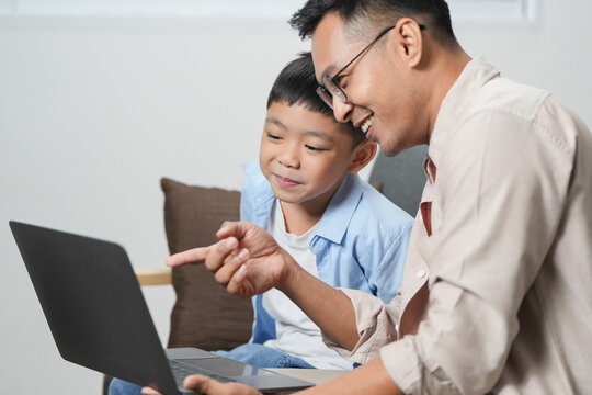 Father and son bonding over laptop, sharing learning moments