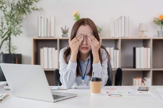 Office Syndrome: Woman rubbing her eyes in frustration at her workspace - Powered by Adobe