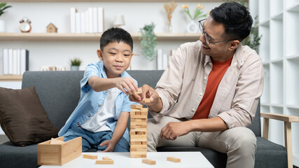 Family Bonding. Father and son playing Jenga together at home.