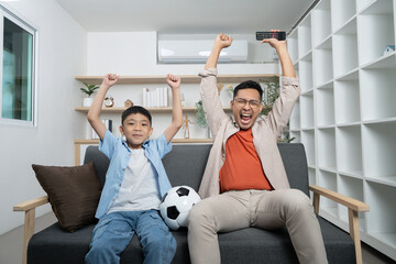 Father and son celebrating a sports victory at home