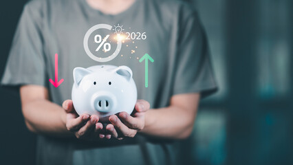 person holding a white piggy bank with rising and falling financial indicators, future interest...