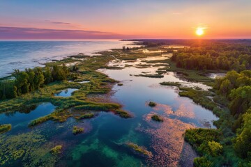 Fototapeta premium Breathtaking aerial view of a colorful sunset over serene swamps and calm waters in a tranquil natural landscape
