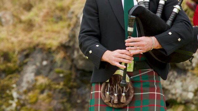 Scottish Piper Playing Bagpipes in Traditional Highland Attire Outdoors