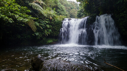Obraz premium Aerial view of Beautiful Sebrangan Waterfall in Forest with Bamboo Trees, Java Island, Indonesia