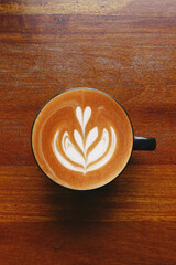 a cup of latte art coffee on wooden background                                                                      