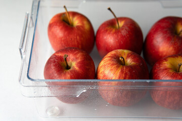 Fresh Royal Gala Red sweet apple in a crisper drawer ready to storage in a fridge at home with white background 
