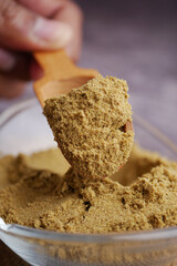 Mixing spices in a wooden scoop for cooking preparation