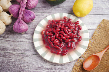 Red beans in a bowl with vegetables and fruit nearby